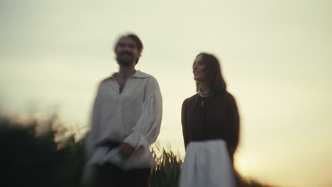 couple in period attire at sunset in a field