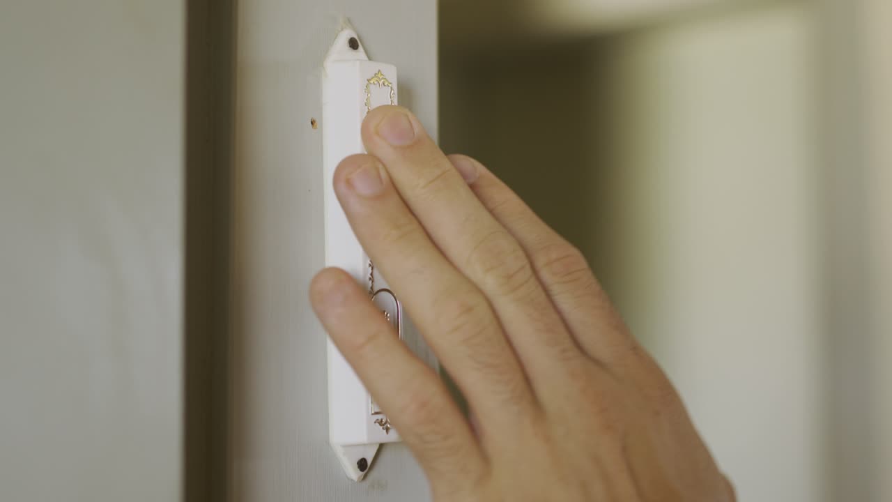 perspectiva posterior de la mezuzá judía - la mano la toca al salir