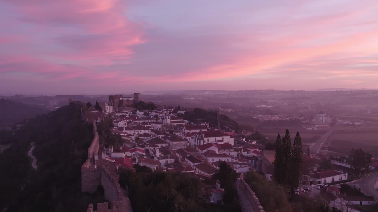 volando cerca de la cruz iluminada en obidos portugal durante el amanecer, aérea