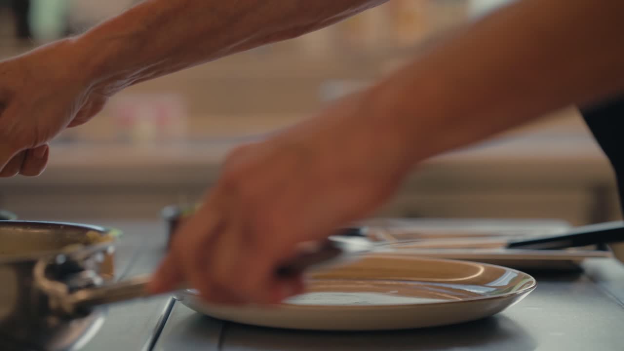 Chef puts fresh mashed potatoes in plate, close up