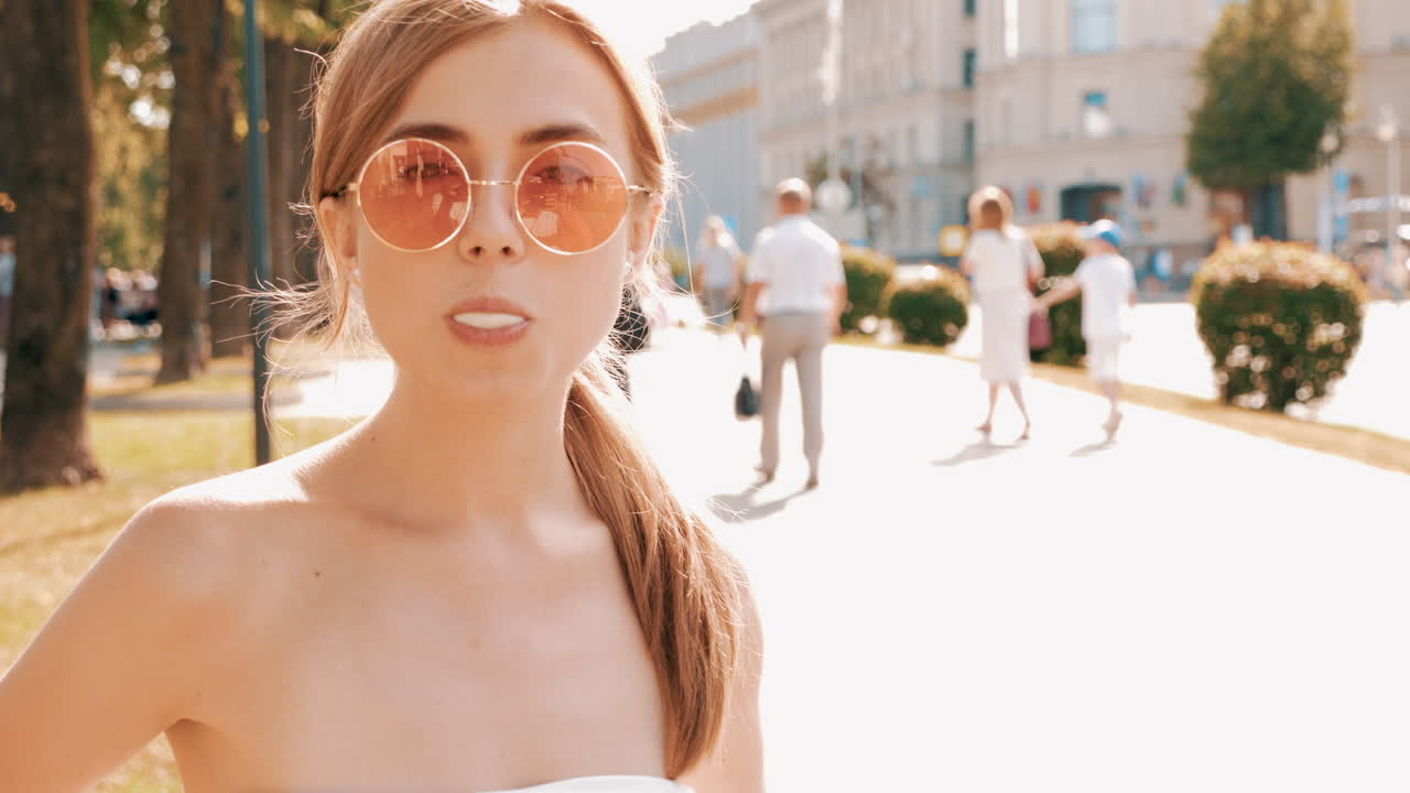 두 명의 젊은 여성들이 도시 공원에서 거품을 불어넣고 있습니다.