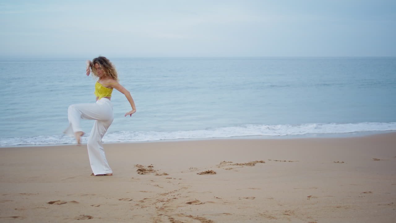그림 같은 바다의 파도 앞에서 바가에서 춤을 추는 젊은 여인. 댄서 공연