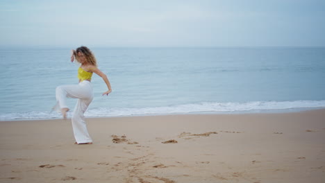 young lady dancing seashore in front picturesque ocean waves. dancer performing