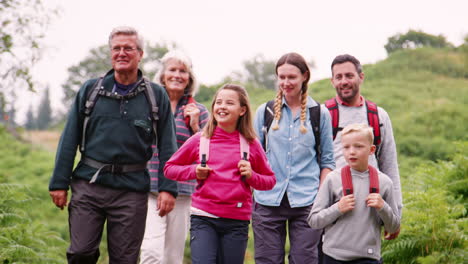 multi generation family talk while hiking in the countryside during a camping holiday, lake district, uk