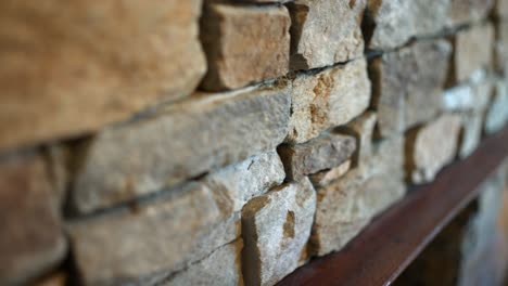 trabajo de piedra interior rústico y áspero por encima de la chimenea con rocas de diferentes formas, tamaños y colores para un aspecto anticuado robusto