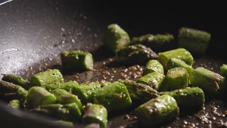 chopped asparagus cooking in pan with olive oil