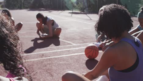 happy diverse female basketball team training on sunny court, in slow motion