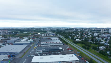 Drone-view-of-panorama-of-Reykjavik,-Iceland-capital-city-and-northernmost-city-in-the-world.-Panoramic-aerial-view-of-the-neighborhood-and-mountains-in-background-with-industrial-district