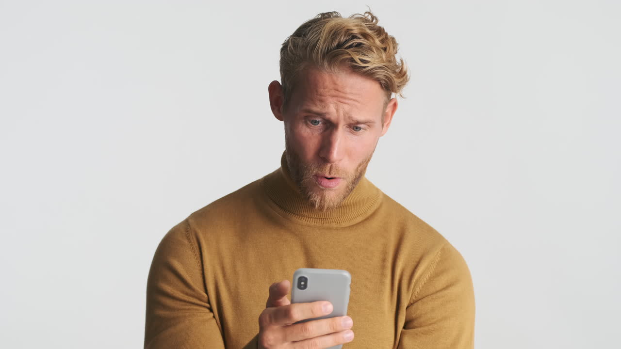 Concerned and happy man using smartphone