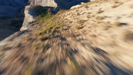 drone aéreo fpv volando rápido sobre formaciones rocosas en un paisaje desértico pintoresco