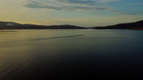 Jet-Skiing-On-Calm-Waters-Of-Lake-Mucharskie-At-Sunset-In-Mucharz,-Poland