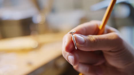 primer plano de un joyero masculino trabajando en la configuración de anillos en el estudio