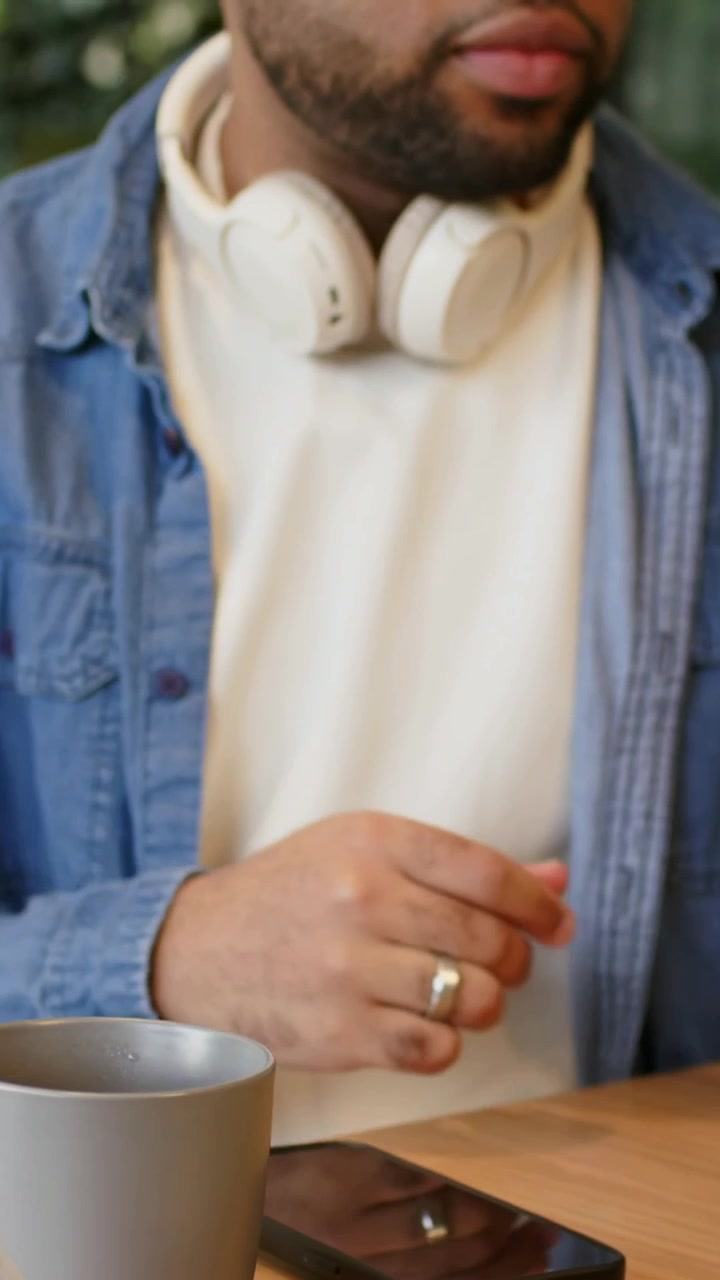Video verticale: Ragazzo in jeans che sposta il microfono, digita alla scrivania per lavoro mentre la telecamera panoramica, con PC, spazio per il testo.