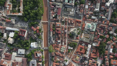 Vista-De-Drones-De-La-Ordenada-Ciudad-Construida-A-Orillas-Del-Río,-Vista-De-La-Ciudad-Llena-De-Edificios-Históricos