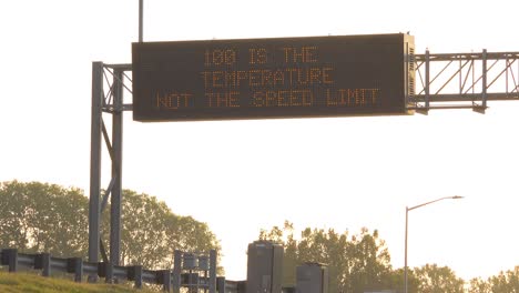 a humorous highway sign on a hot day says 100 degrees is the temperature not the speed limit