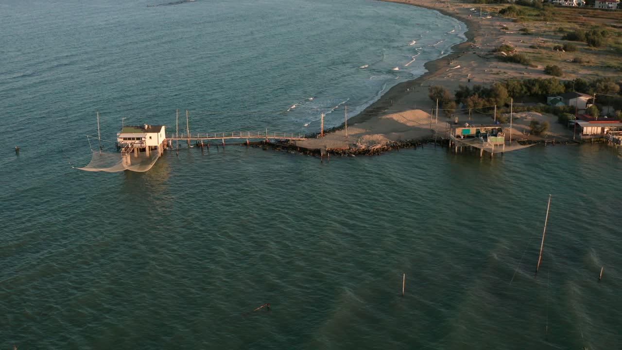 toma aérea de los valles cerca de ravenna donde el río desemboca en el mar con las típicas cabañas de pescadores al atardecer
