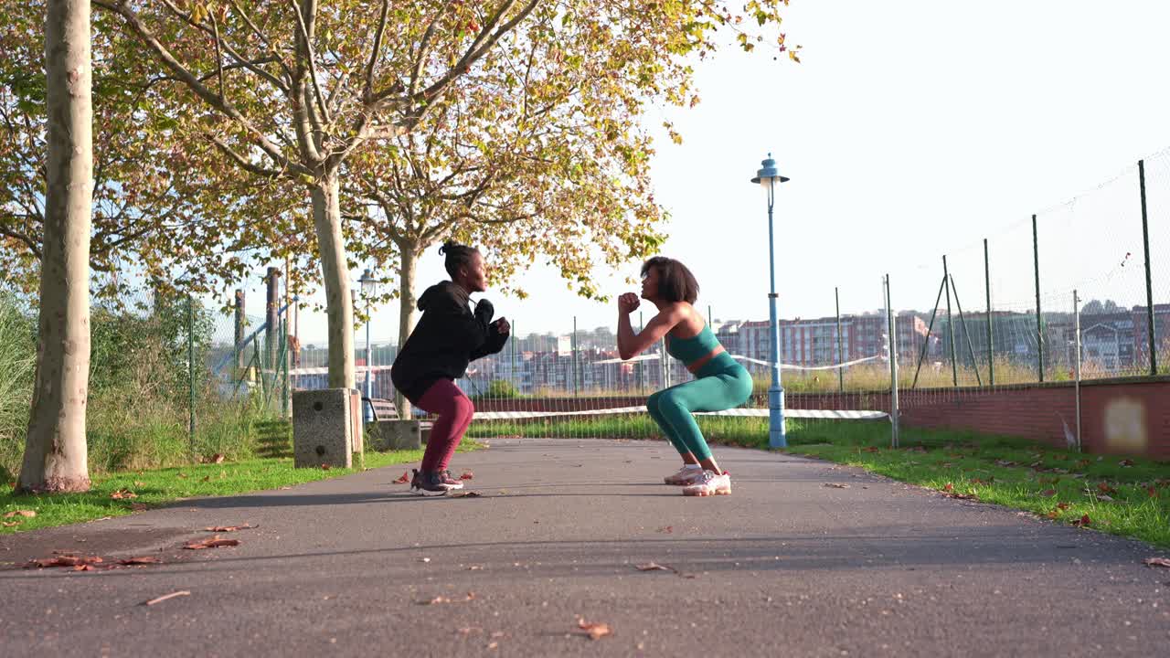Dos mujeres haciendo saltos de tijera al aire libre en un parque