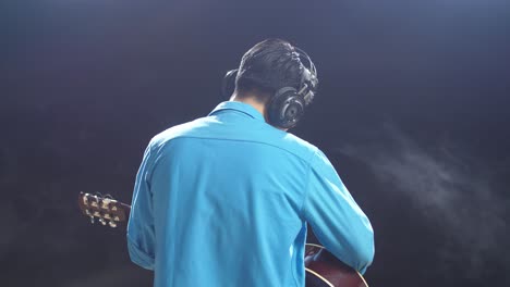 man playing acoustic guitar in recording studio