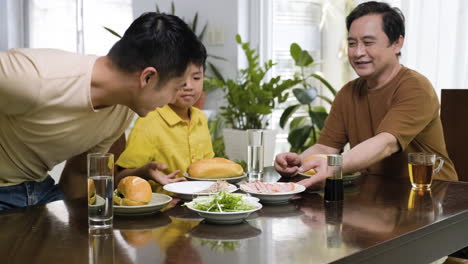 hombres asiáticos y un niño sentados en la mesa