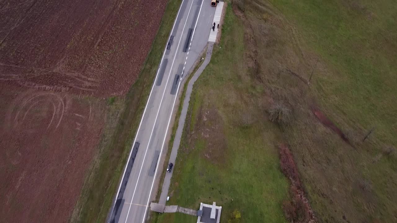 주변에 푸른 초원이 있는 작지만 긴 시골길의 공중 탑샷