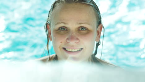 Mujer-Joven-Feliz-En-El-Agua-Azul-Clara-De-La-Piscina