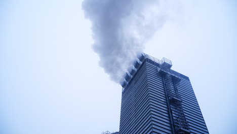 White puffs of smoke from a modern heating stove. White puffs of smoke from a modern heating stove near grain elevator