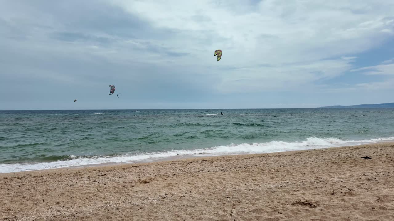 personas haciendo kiteboard en una hermosa playa con cielos azules claros