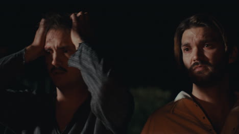men in distress in a dark setting
