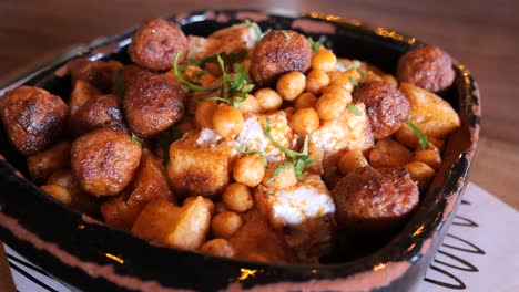 close up of a delicious meal with meatballs, chickpeas, potatoes and a white sauce