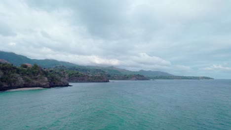 Cloudy-day-fly-by-of-stone-and-sand-beach-fronts