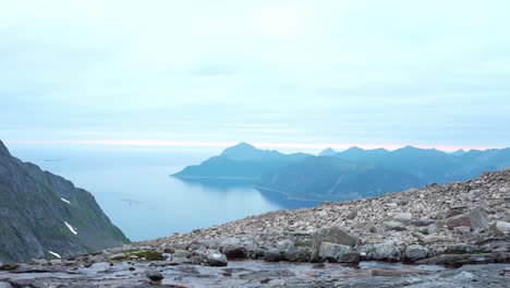 kvaenan mountain peaks with calm lake in senja island, norway