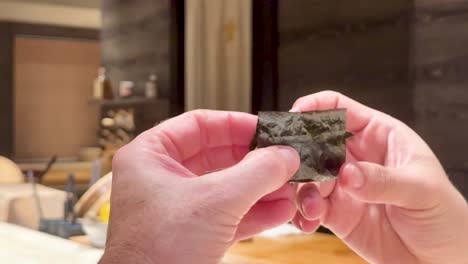 manos haciendo sushi uni con envoltura de algas