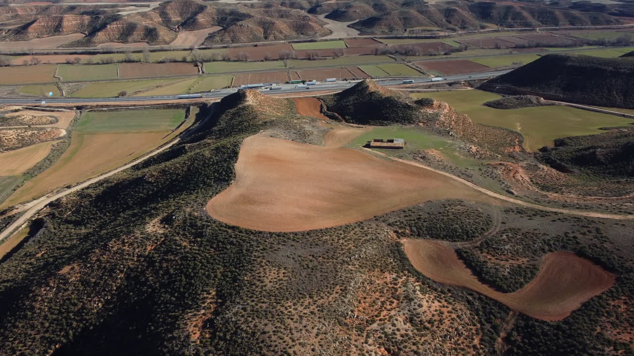 Aerial view of Spanish countryside with hills, fields and a highway