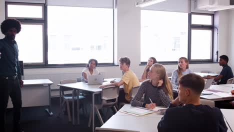 male high school teacher standing next to interactive whiteboard and teaching lesson