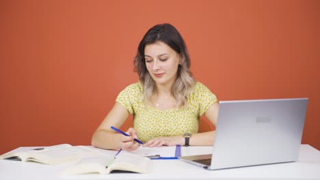 mujer joven trabajando en una computadora portátil con expresión feliz.