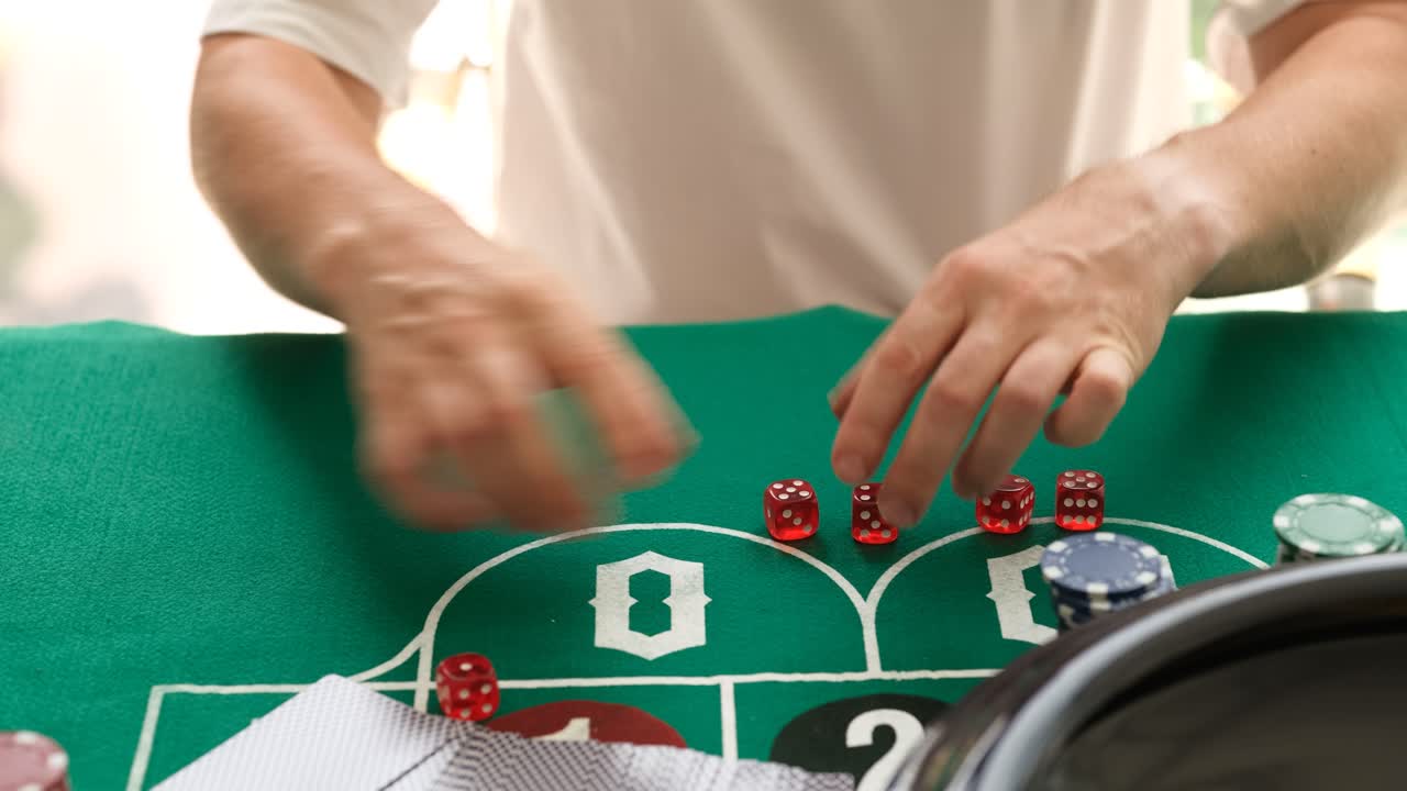 Mani che lanciano e impilano dadi rossi su un tavolo da casinò verde