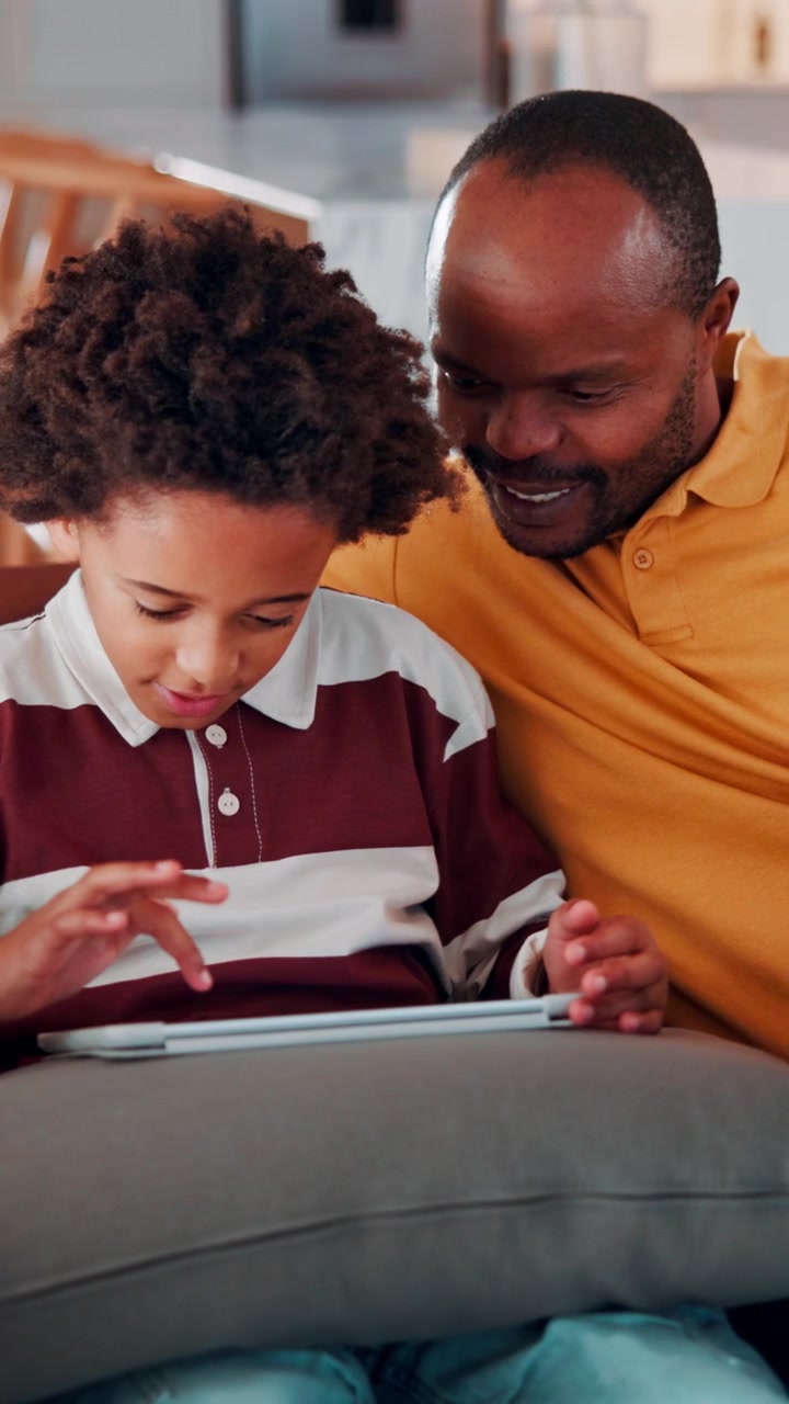 Padre e figlio che usano un tablet digitale insieme a casa