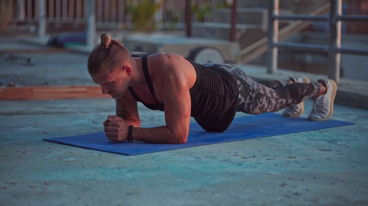Fit Man Performing Plank Exercise on Yoga Mat Outdoors