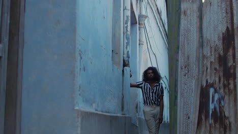 stylish man posing in a narrow urban alley