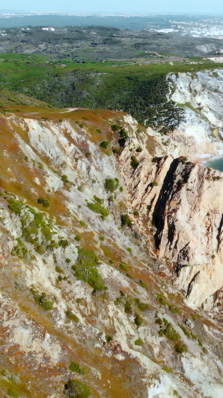 Captura de dron de acantilados de piedra caliza escarpados con oleaje rompiendo y espuma blanca, erosión costera dramática. Contenido multimedia.