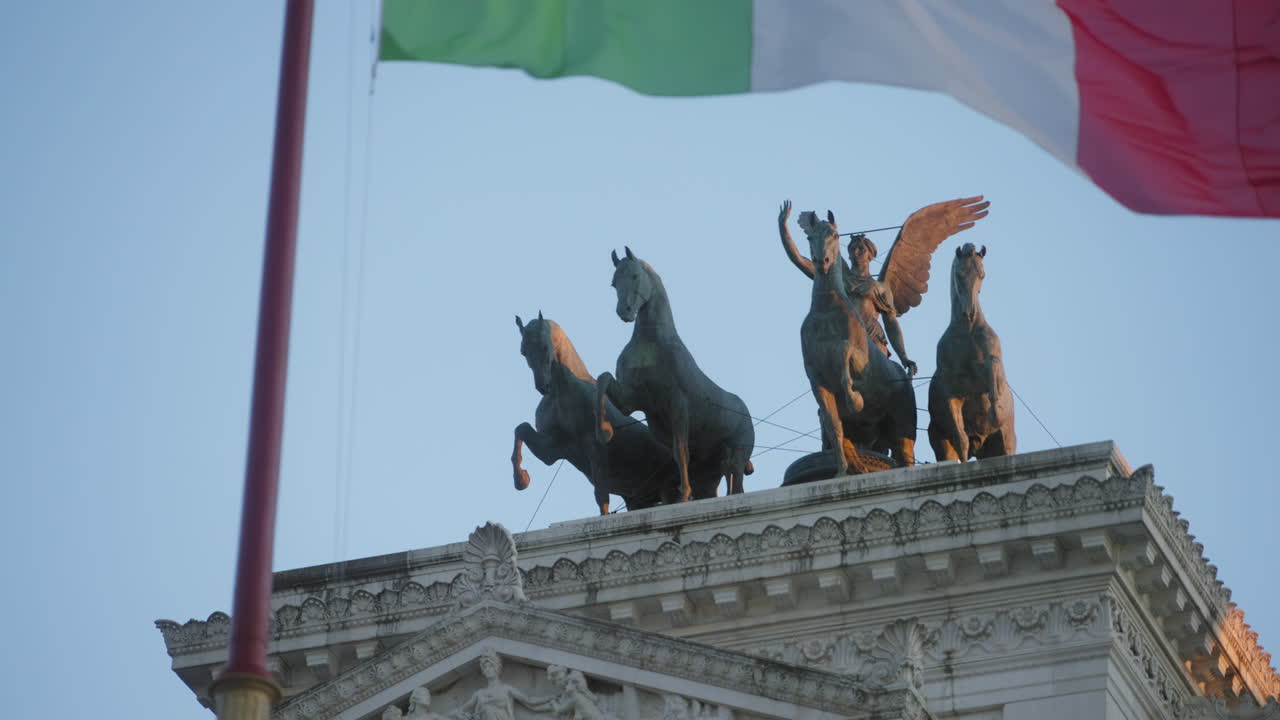 Scultpure on top of Vittorio Emmanuel II monument in Rome, Italy, with Italian wave flying on the foreground
