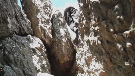 persona escalando una montaña rocosa