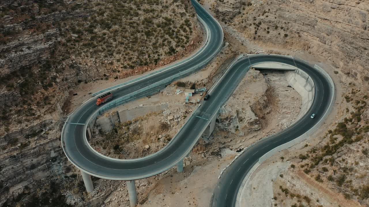 antena sobre la nueva y sinuosa carretera cpec en fort munro en pakistán con camión y coche pasando