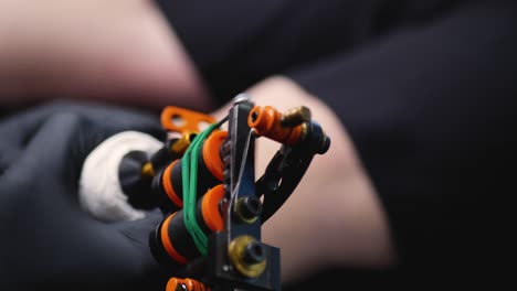 Close-up-slow-motion-shot-of-tattoo-machine-gun-needle-bouncing-in-skin-with-gloves-tattooing-art-design-shop-Sydney-NSW-Australia-4K