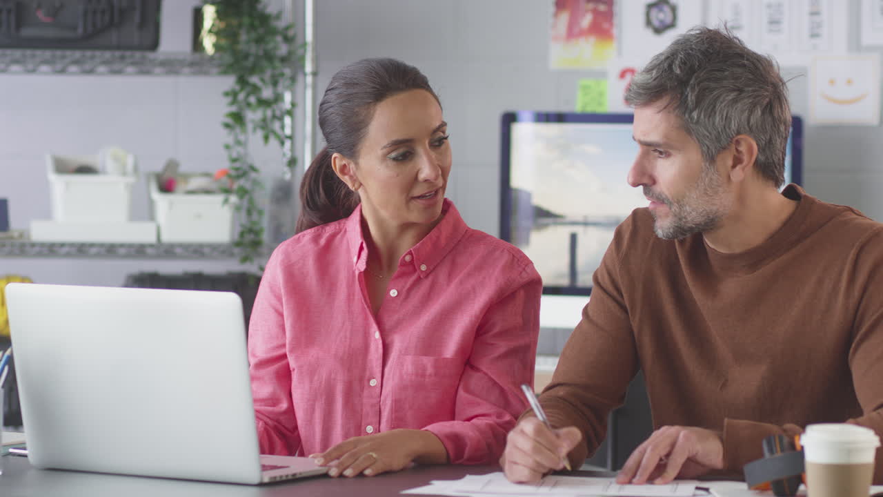 hombre de negocios y mujer de negocios en una oficina creativa trabajando juntos en un escritorio en una computadora portátil
