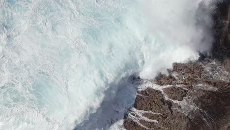 Overhead-view-of-waves-crashing-onto-rocky-coast-off-of-Oahu-Hawaii