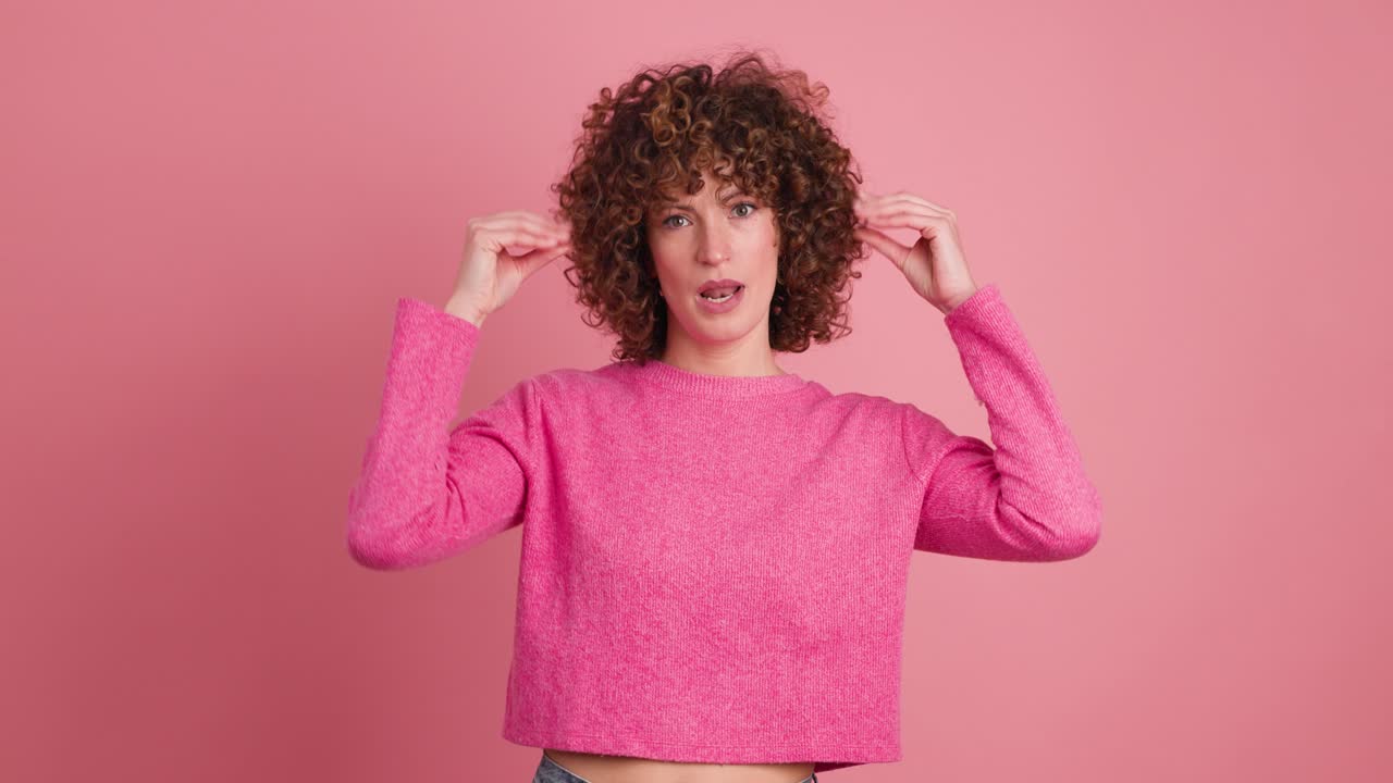 Bored young woman saying blah blah with hands gesture on pink background