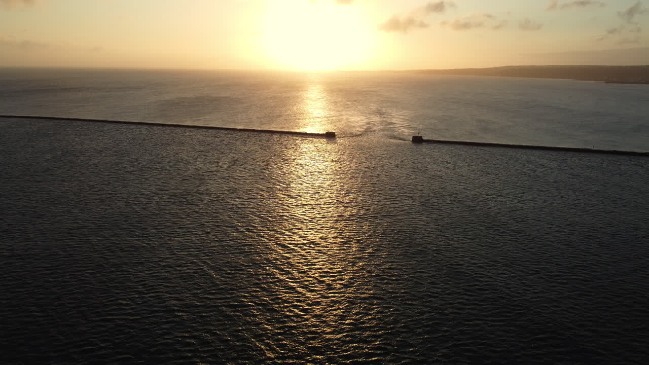 Sunset over the ocean with breakwater