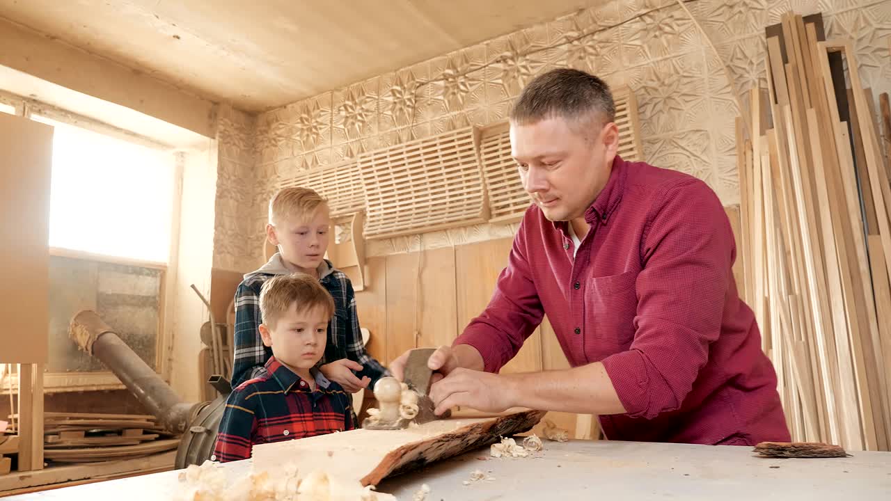 가족, 목공, 목공 및 사람 개념: 아버지가 아들에게 목공을 가르니다.