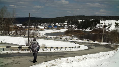 snowy rural road with woman walking